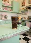 Brown insulated tumbler with gold rim on a kitchen counter