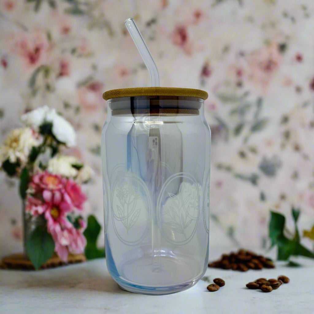 Floral oval engraved glass coffee can tumbler on counter with floral background