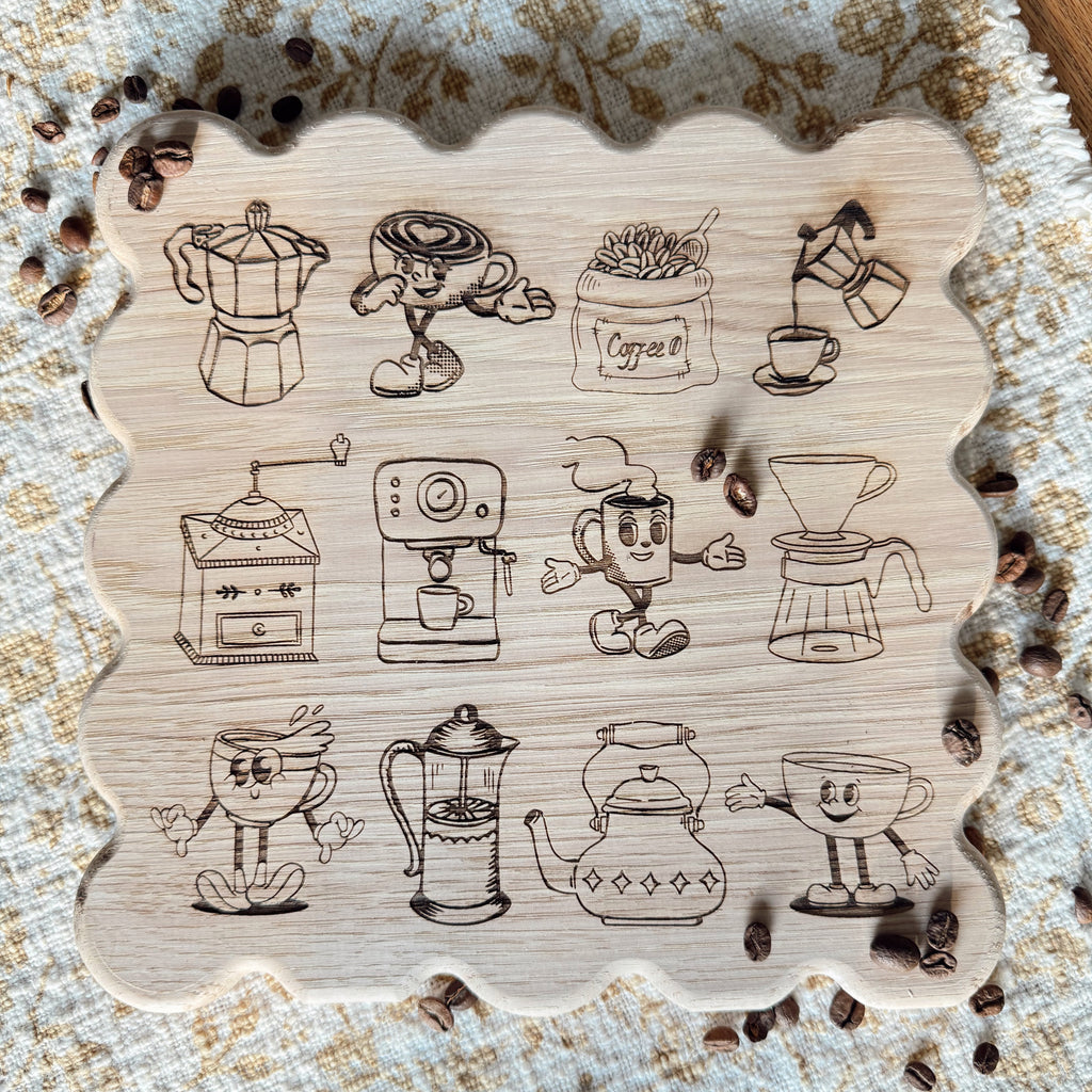 Scalloped wooden cutting board with retro coffee illustrations engraved in the wood on a placemat.